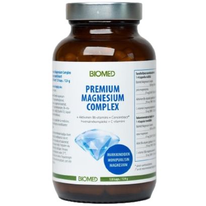 A brown bottle labeled BIOMED PREMIUM MAGNESIUM COMPLEX with supplement facts and product information displayed on a white background. The bottle is cylindrical with a matte finish and a dark, likely plastic cap. The label features sans-serif fonts in white and blue on dark backgrounds. A prominent blue crystal graphic is in the center of the label. No people or hands are visible.