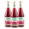 Three glass bottles of Biotta Pomegranate juice are shown side by side. The transparent bottles have a slight taper toward the neck, finished with metallic gold screw caps. Labels are green and white with glossy surfaces, showing a pomegranate image and bold sans-serif “Biotta” text. Background and setting are neutral and unadorned. No people or hands are present in the image.