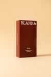 Blank& Evie Kasvoöljy; punainen suorakulmainen mattapintainen rasia näyttää tekstin ”BLANK&” yläosassa ja ”Evie Calming face oil with CBD” alaosassa selkeällä nykyaikaisella groteskikirjasimella; tuote kuvattu tasaista beigeä taustaa vasten; ei ihmisiä tai käsiä kuvassa; asetelma välittää rauhallisen tunnelman.