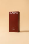 Blank& Veya Kasvosuihke; tummanpunainen suorakulmainen rasia tekstillä BLANK& yläosassa, alla teksti Veya Glass Glow Face Mist with CBD ja maininta säteilevästä lopputuloksesta, vaaleaa beigeä taustaa vasten; rasian pinta sileä ja kulmat terävät; teksti selkeällä nykyaikaisella groteskikirjasimella; ei ihmisiä tai käsiä, kuva otettu edestä tasaisessa valaistuksessa.
