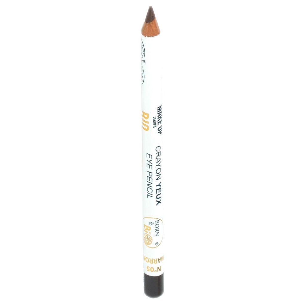 Valkoinen silmäkynä teroitetulla ruskealla kärjellä, merkitty Eye Pencil ja Crayon Yeux mustalla tekstillä sekä lisäksi kultaisia ja mustia yksityiskohtia rungossa; kynä lieriömäinen mattapinnalla; etikettitypografia selkeää groteskikirjasinta; tuote kuvattu yksinkertaisella taustalla ilman näkyvää pakkausta; ei ihmisiä tai käsiä kuvassa.