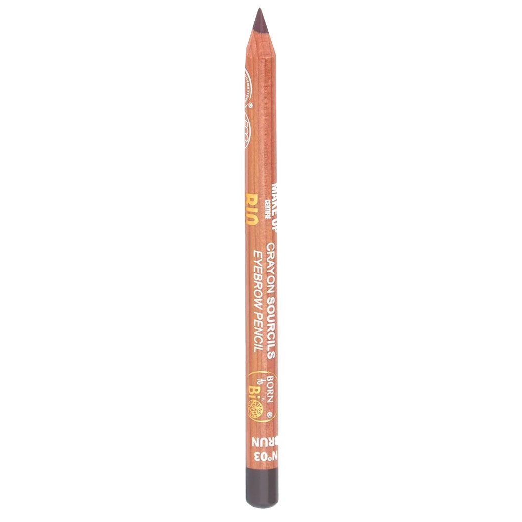 Ruskea kulmakynä seisoo pystyssä valkoisella taustalla; kynä lieriömäinen mattapinnalla ilman korkkia kärjessä; painettu etikettiteksti näyttää sanat BROWN ja EYEBROW PENCIL sekä pienempiä lisätietoja; ei pakkausta, ihmisiä tai muita esineitä kuvassa.