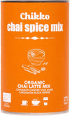 Chikko Luomu Chai Latte Mix; oranssi sylinterinmuotoinen purkki mattapinnalla, merkitty "Chikko chai spice mix" selkein lihavoiduin kirjaimin; pakkauksessa kuvituksia kulhosta, mausteista ja kuppikuvakkeista; lyhyt etikettiteksti listaa luomu-chai-latte-seoksen ainesosat: kaneli, inkivääri, tähtianis, kardemumma, musta pippuri ja chai-mausteet; tausta yksivärinen, ei ihmisiä näkyvissä; purkissa korostetaan luomua chai latte -mausteseosta.