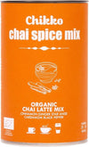 Chikko Luomu Chai Latte Mix; oranssi sylinterinmuotoinen purkki mattapinnalla, merkitty "Chikko chai spice mix" selkein lihavoiduin kirjaimin; pakkauksessa kuvituksia kulhosta, mausteista ja kuppikuvakkeista; lyhyt etikettiteksti listaa luomu-chai-latte-seoksen ainesosat: kaneli, inkivääri, tähtianis, kardemumma, musta pippuri ja chai-mausteet; tausta yksivärinen, ei ihmisiä näkyvissä; purkissa korostetaan luomua chai latte -mausteseosta.