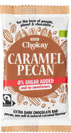 Chokay Luomu Tumma Karamelli & Pekaani Suklaa; suorakaiteen muotoinen suklaakääre nimellä A Chokay Caramel Pecan, tumma suklaa, 0 % lisättyä sokeria, Fairtrade ja luomu; maininnat pekaanipähkinästä, merisuolasta ja luonnollisesta karamellin mausta; ruskea-valkoinen mattapakkaus pekaanikuvituksin; groteskifontit; ei ihmisiä tai käsiä; neutraali tausta, studiokuva.