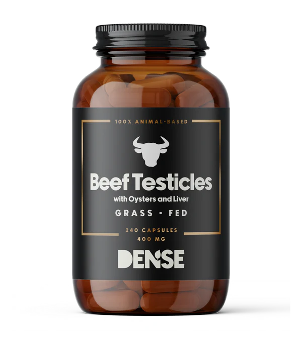 DENSE Härän Kivekset; ruskea muovipullo sylinterinmuotoisena mustalla mattapintaisella etiketillä; etiketissä teksti "Beef Testicles with Oysters and Liver, Grass-Fed, 240 Capsules, 400 mg"; keskellä lihavoitu härän pää -kuvitus; pääosin valkoista groteskitekstiä; pullon korkki on yhtenäisen musta rihlatuin reunoin; tausta valkoinen, tuote keskitettynä kuvassa.