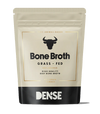 DENSE Luuliemijauhe; beige ja musta pussi tekstillä "Bone Broth Grass-Fed" härkäkuvakkeineen, mauttomaksi valmistettua laadukasta naudan luuliemijauhetta, 50 grammaa; taipuisa mattapintainen pystyssä seisova pakkaus; lihavoitu musta ja valkoinen groteskifontti, etikettiteksti selkeästi aseteltu etusivulle; tuote keskitettynä valkoista taustaa vasten, ei ihmisiä tai käsiä.