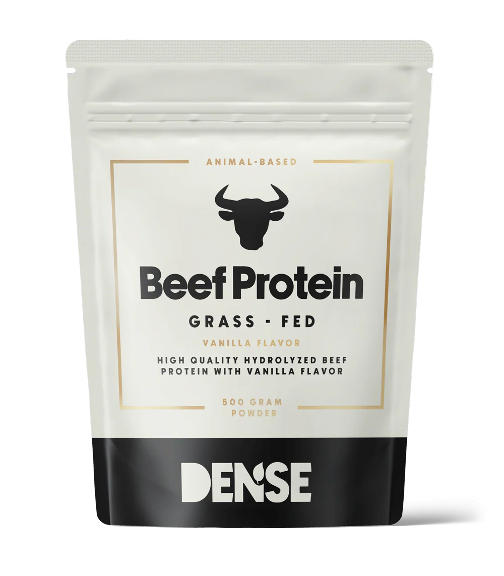 DENSE Nautaproteiini Vanilja; valkoinen ja musta pussi, merkitty Beef Protein Grass-Fed Vanilla Flavor, sonnikuvake, sisältää 500 g DENSE-merkin hydrolysoitua nautaproteiinijauhetta eläinperäiseen ravitsemukseen; pussi on suorakulmainen mattapinnalla ja seisoo pystyssä; etiketin typografia lihavaa, groteskia mustaa tekstiä pääosassa ja pienempää kultaista kirjoitusta; ei ihmisiä tai rekvisiittaa näkyvissä; tuote kuvattu vaaleaa taustaa vasten suoraan edestä.