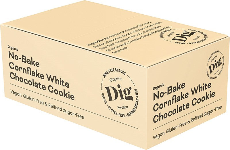 Dig Luomu Cornflake-Valkosuklaakeksi; beige suorakulmainen laatikko mattapinnalla, merkitty Organic No-Bake Cornflake White Chocolate Cookie, korostaen vegaanisuutta, gluteenittomuutta ja maidottomuutta; DIG Sweden -logo näkyy sivulla; etiketissä lihava mustan värinen groteskifontti pääteksteille; pakkaus on suljettu, sisältöä ei näy; kuvattu valkoista taustaa vasten, ei ihmisiä tai käsiä näkyvissä.