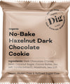 A beige package labeled No-Bake Hazelnut Dark Chocolate Cookie features ingredients and notes that it is vegan, gluten-free, and refined sugar-free. The packaging highlights the presence of rich hazelnuts blended with dark chocolate. The pouch is matte with a rectangular shape and resealable top. Typography varies in size and weight, all clearly legible on the front. The product is photographed against a plain white background without people or objects present.
