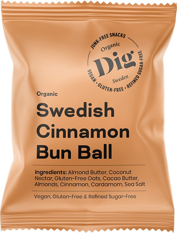 A tan, matte-finish snack package labeled “Swedish Cinnamon Bun Ball” is visible. Text in a circular arrangement notes organic, vegan, gluten-free, and refined sugar-free. The rectangular pouch displays product information and an ingredients list beneath the main text. No people or hands are present. Plain background. A tan snack package labeled Swedish Cinnamon Bun Ball features circular text highlighting its organic, vegan, gluten-free, and refined sugar-free qualities. Ingredients are listed below on