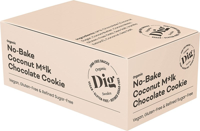 Dig Luomu Kookossuklaakeksi; beige laatikko Dig Organic No-Bake Coconut M*lk Chocolate Cookie -tuotetta, merkitty vegaaniseksi, gluteenittomaksi ja puhdistetusta sokerista vapaaksi, tuotetiedot ja luomusertifikaatit painettu sivuille; suorakulmainen pahvipakkaus mattapinnalla; groteskifontit ruskealla ja vihreällä; laatikko lepää valkoista taustaa vasten, ei ihmisiä tai rekvisiittaa kuvassa.