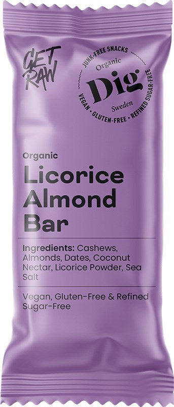 Dig Luomu Lakritsi-Mantelipatukka; violetti patukan kääre, merkitty Organic Licorice Almond Bar, sisältää ainesosina cashewpähkinöitä, manteleita ja taateleita; tämä vegaaninen, gluteeniton ja ilman puhdistettua sokeria valmistettu herkku näyttää GET RAW- ja Dig Sweden -logot kääreessä; pakkaus on suorakulmainen mattapinnalla, luettavaa lihavaa groteskitekstiä; ei käsiä tai ihmisiä näkyvissä lähikuvassa yksivärista taustaa vasten.