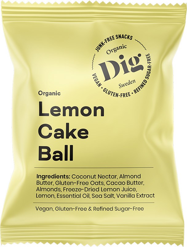 A yellow rectangular snack package with a matte finish is labeled Dig in large bold black font. The package also displays “organic Lemon Cake Ball,” and lists vegan, gluten-free, and refined sugar-free with simple sans-serif text. No people or props are visible. The background is plain white. A yellow snack package labeled Dig contains an organic Lemon Cake Ball. Vegan, gluten-free, and refined sugar-free ingredients and features are listed on the front in black text.
