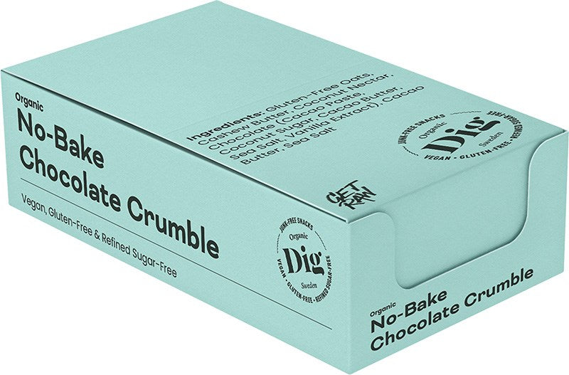 Dig Luomu Suklaacrumble; vaaleansininen suorakulmainen laatikko mattapinnalla, merkitty ”Organic No-Bake Chocolate Crumble” selkeällä groteskifontilla; lisätekstissä mainitaan vegaaninen, gluteeniton ja puhdistetusta sokerista vapaa; etupaneelissa ainesosa- ja merkkitietoja; tuote esillä yksivärista taustaa vasten ilman ihmisiä tai rekvisiittaa.