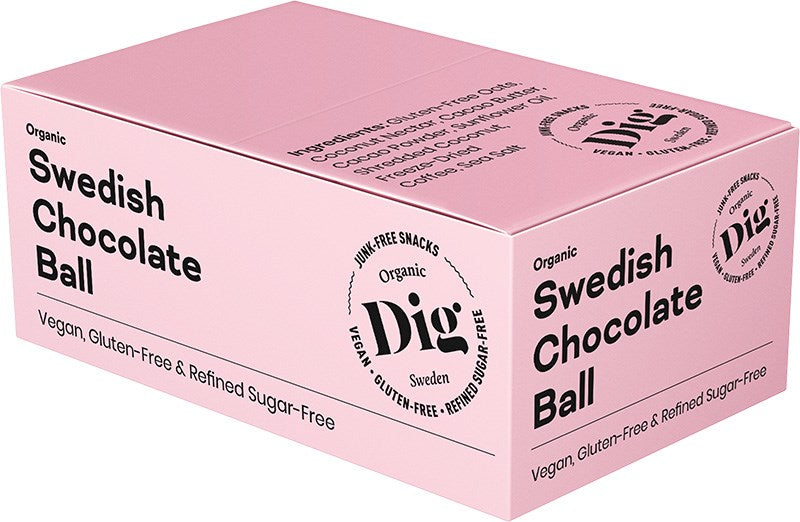 Dig Luomu Suklaapallo; vaaleanpunainen suorakulmainen laatikko mattapinnalla; etiketissä lukee Organic Swedish Chocolate Ball, merkitty vegaaniseksi, gluteenittomaksi ja puhdistetusta sokerista vapaaksi; Dig-merkin logo näkyy etupuolella; ainesosaluettelo painettu laatikon yläosaan pienellä tekstillä; ei ihmisiä tai käsiä näkyvissä; neutraali, yksivärinen tausta pehmeällä valaistuksella pelkässä tuotekuvassa.