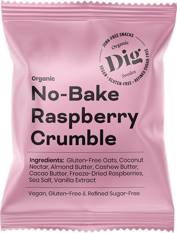 Dig Luomu Vadelmacrumble; vaaleanpunainen välipalapakkaus, merkitty No-Bake Raspberry Crumble, sisältää gluteenitonta kauraa, kookospähkinänektaria, mantelivoita, cashewvoita, kaakaovoita, vadelmia, merisuolaa ja vaniljauutetta; pakkaus on mattapintainen valkoisella ja tummanpinkillä selkeällä groteskitekstillä; pussi on suorakulmainen suljetulla yläreunalla; tausta valkoinen; ei ihmisiä tai käsiä näkyvissä.