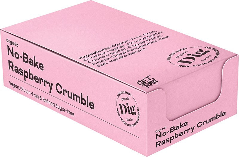 Dig Luomu Vadelmacrumble; vaaleanpunainen suorakulmainen laatikko mattapinnalla; etiketissä lukee No-Bake Raspberry Crumble, merkitty luomuksi, vegaaniseksi, gluteenittomaksi ja sokerittomaksi; ainesosat painettu laatikon yläpintaan; Dig-merkki näkyy sivupaneelissa yhdessä terveellisiä ainesosia koskevan tekstin kanssa; ei ihmisiä tai käsiä kuvassa; neutraali tausta; tuote kuvattu hieman viistosti.