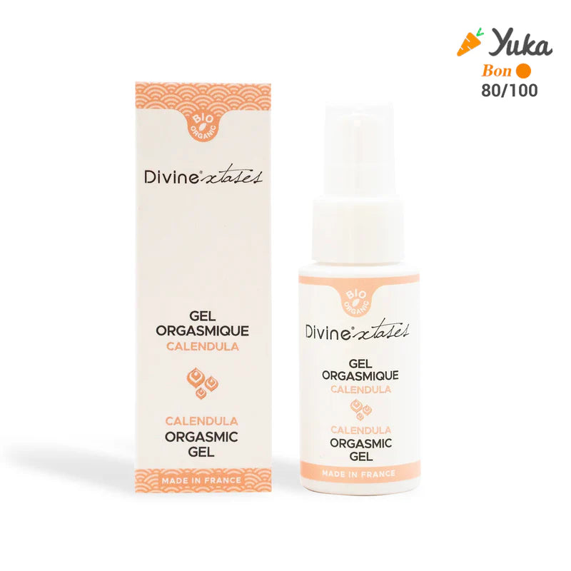 DivineXtases Orgasmigeeli; pullo ja rasia Divine Extase Calendula Orgasmic Gel -geeliä, merkitty Made in France, Yuka-luokitus 80/100 oikeassa yläkulmassa; molemmat esineet valkoisia ja persikanvärisiä mattapinnalla, koristeellisin kuviokorostuksin; etikettien kirjasin siisti ja groteski; ei ihmisiä tai käsiä; tausta tasainen, todennäköisesti valkoinen tai vaaleasävyinen.