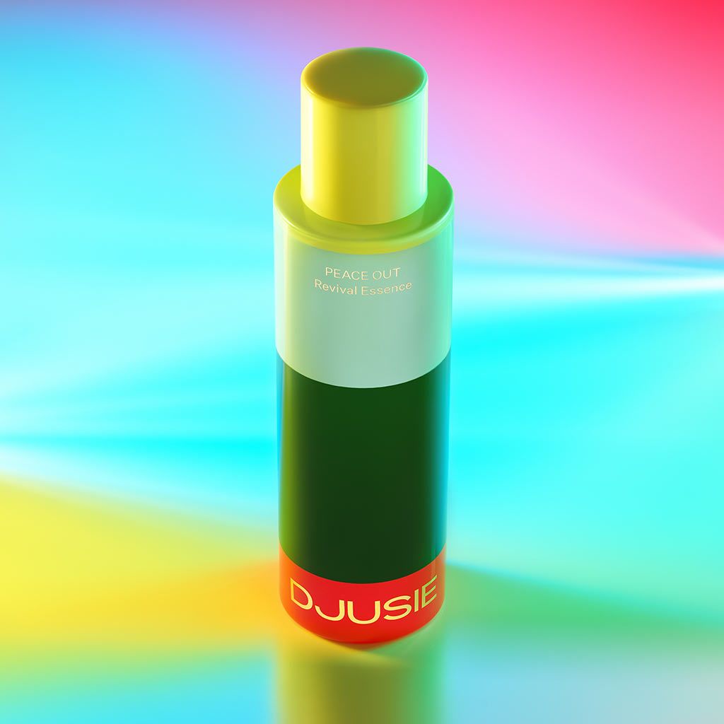 A vibrant bottle labeled DJUSIE and PEACE OUT Revival Essence stands on a glowing multicolored background with hues of blue, yellow, and pink. The bottle is cylindrical with a pump dispenser, made of glossy material, and features clear sans-serif text on the label. There are no people or hands in the image. The shot is well-lit and taken from eye level.