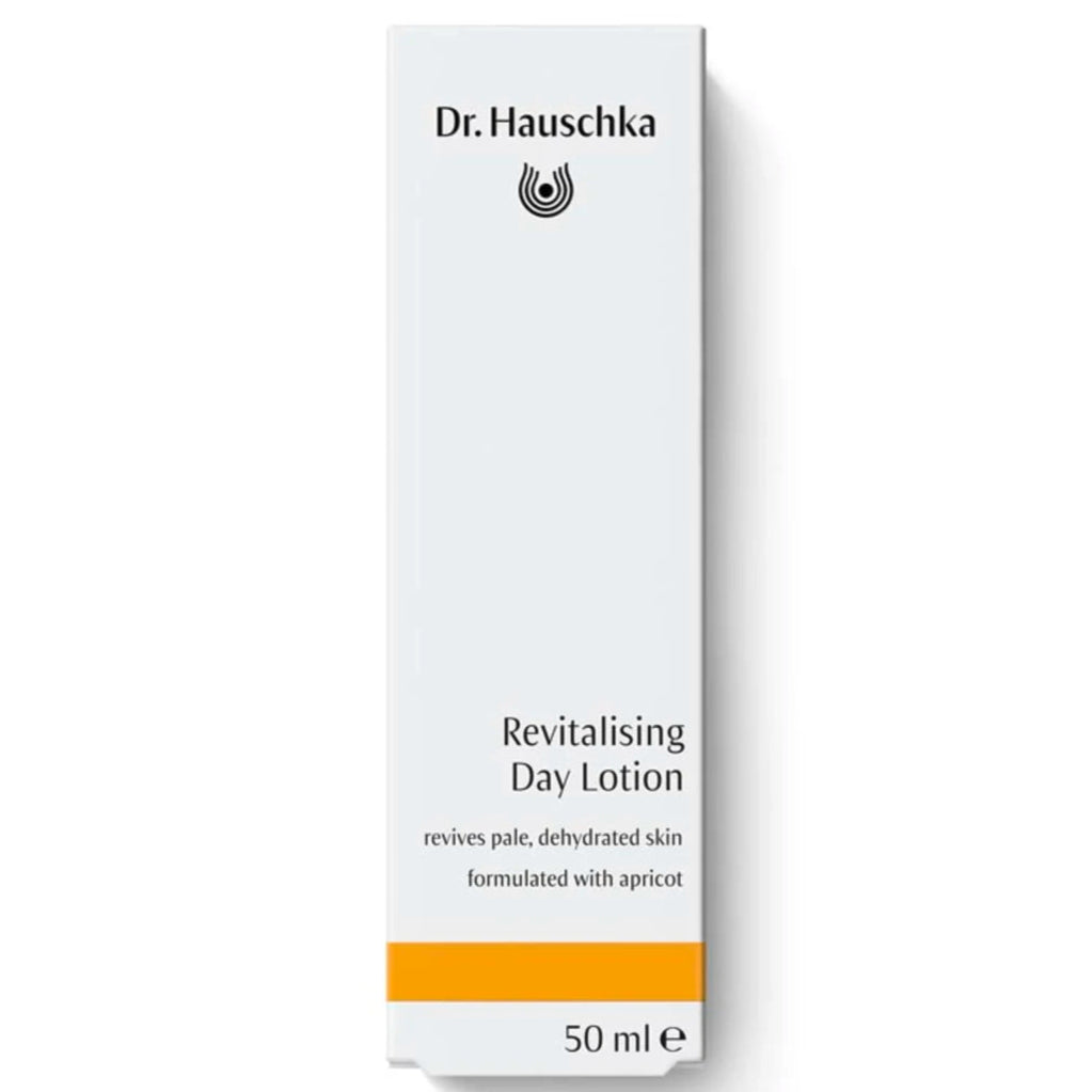 Dr. Hauschka Aktivoiva Kosteusvoide; valkoinen suorakaiteen muotoinen rasia Dr. Hauschka Revitalising Day Lotion -tuotetta, 50 ml, kalpealle tai kuivuneelle iholle, koostumus ravitsevalla aprikoosilla; pinta mattapintainen, muoto korkea suorakulmainen terävin reunoin; rasiassa niukkaa tikkukirjasintekstiä ja oranssi raita alaosassa; ei käsiä tai ihmisiä näkyvissä; tausta tasainen valkoinen, tuote kuvattu edestä.