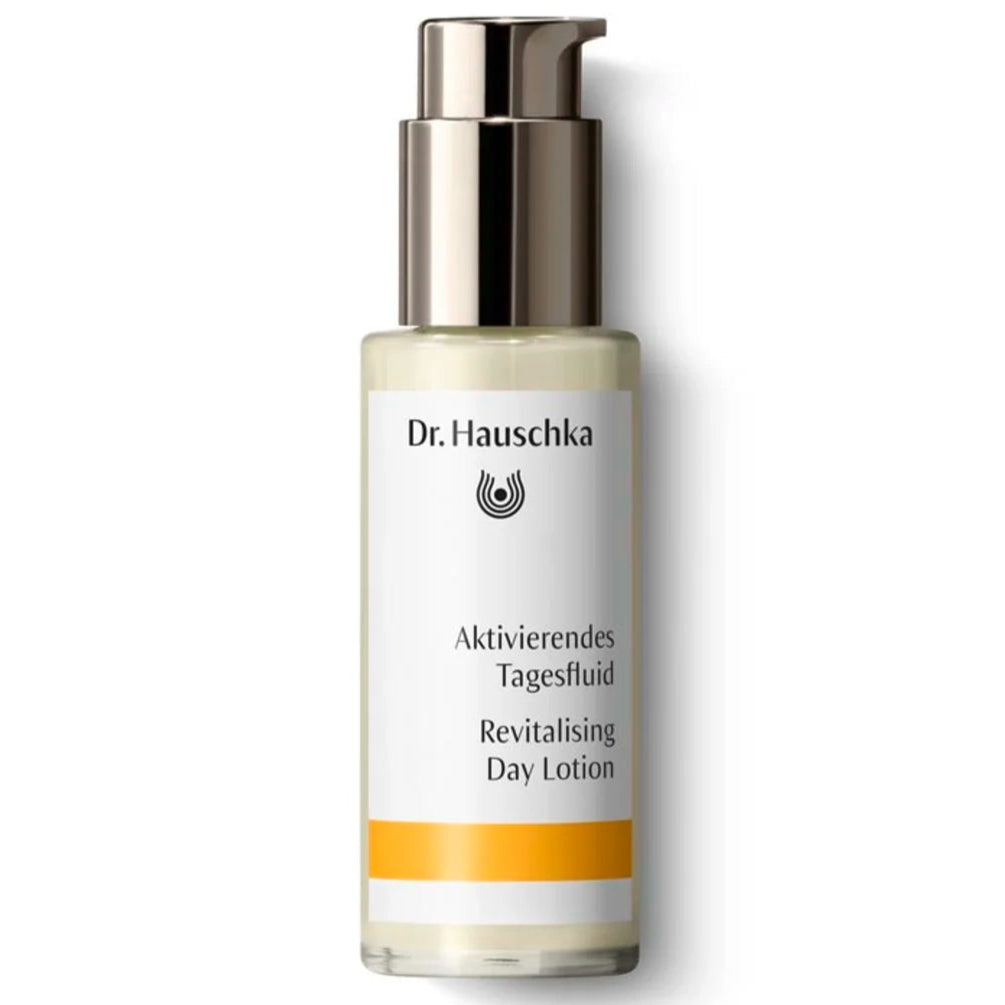 Dr. Hauschka Aktivoiva Kosteusvoide; pullo Dr. Hauschka Revitalising Day Lotion -tuotetta pumppuannostelijalla, lieriömäinen muoto, kiiltäväpintainen valkoinen etiketti yhdellä vaakasuoralla keltaisella raidalla alaosassa, painettua tekstiä mustana ja kultaisena tikkukirjasin- ja antiikvakirjasimin; sekä saksaksi että englanniksi; pullo pystyssä tasaisella vaalealla taustalla; ei ihmisiä tai käsiä näkyvissä.