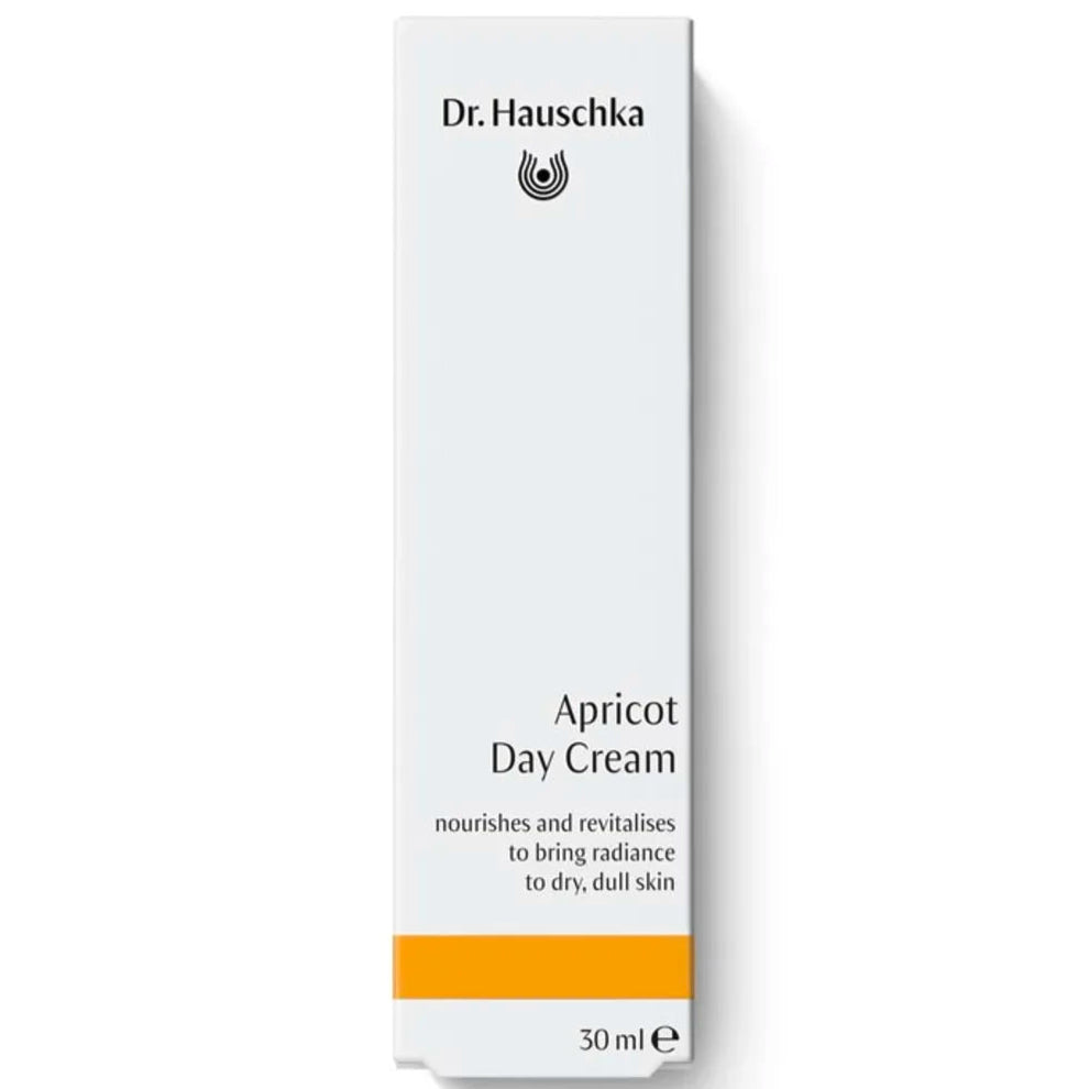 Dr. Hauschka Aprikoosivoide; valkoinen rasia Dr. Hauschka Apricot Day Cream -tuotetta, 30 ml, keltainen raita alaosassa; rasiassa yksinkertaista tikkukirjasin- ja antiikvatypografiaa brändille ja tuotenimelle; luettava teksti sisältää ”Dr. Hauschka” ja ”Apricot Day Cream”; pinta mattapintainen; ei ihmisiä tai käsiä näkyvissä, tausta tasainen valkoinen; koostumus ravitsee ja uudistaa, tuoden säteilevän kosteuden kuivalle, elottomalle iholle.