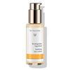 A bottle of Dr. Hauschka Soothing Day Lotion with a gold pump and white label, featuring calming text in German and English and an orange band near the bottom. The bottle is cylindrical with a matte finish. The label uses sans-serif black lettering; “Soothing Day Lotion” is the main text visible. The background is plain white, product centered, no people or hands in the image.