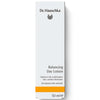 Dr. Hauschka Tasapainottava Kosteusvoide; valkoinen 50 ml:n rasia Dr. Hauschka Balancing Day Lotion -tuotetta, erityisesti koostettu ketohanhikilla rasvoittuvalle ja sekaiholle; suorakaiteen muotoinen pahvipakkaus mattapinnalla; pelkistettyä tikkukirjasin- ja antiikvatypografiaa mustana ja kultaisena etusivulla; näkyvässä tekstissä tuotenimi ja avaintiedot; tausta vaalea ja tasainen; ei ihmisiä, käsiä tai rekvisiittaa näkyvissä; studiotyylinen kuva suorassa kulmassa.