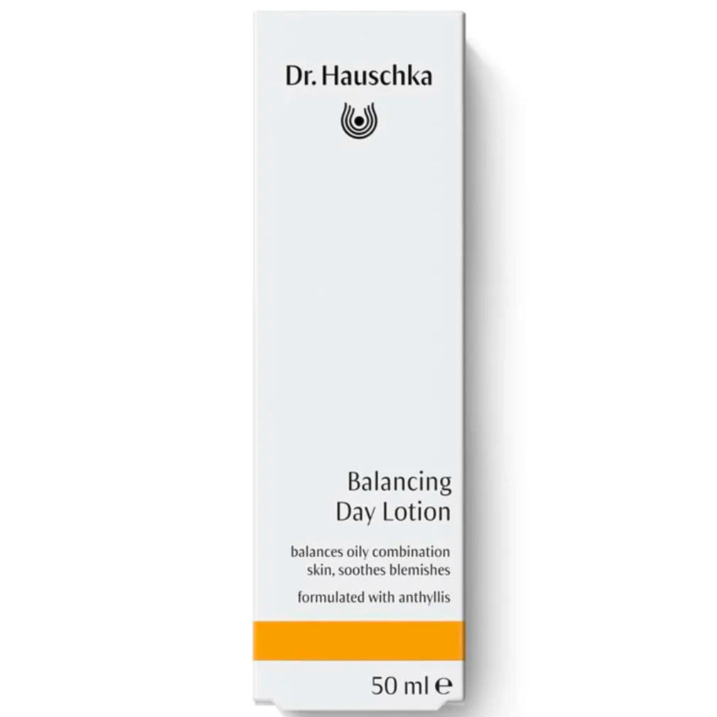Dr. Hauschka Tasapainottava Kosteusvoide; valkoinen 50 ml:n rasia Dr. Hauschka Balancing Day Lotion -tuotetta, erityisesti koostettu ketohanhikilla rasvoittuvalle ja sekaiholle; suorakaiteen muotoinen pahvipakkaus mattapinnalla; pelkistettyä tikkukirjasin- ja antiikvatypografiaa mustana ja kultaisena etusivulla; näkyvässä tekstissä tuotenimi ja avaintiedot; tausta vaalea ja tasainen; ei ihmisiä, käsiä tai rekvisiittaa näkyvissä; studiotyylinen kuva suorassa kulmassa.