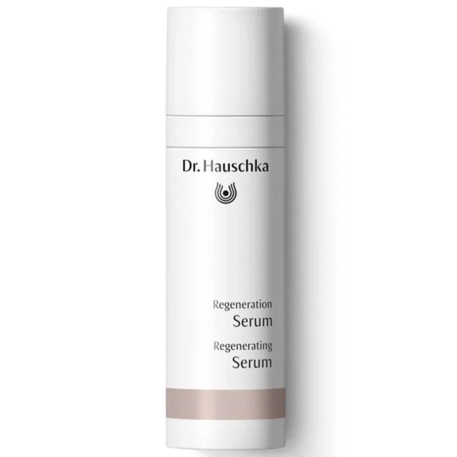 Dr. Hauschka Uudistava Seerumi; valkoinen lieriömäinen muovipullo Dr. Hauschka Regeneration Serum -tuotetta mattapinnalla ja beigenvärisellä vaakasuoralla nauhalla tyvellä; etusivun etiketissä mustaa tikkukirjasintekstiä tuotenimelle ja brändilogolle; pullo pystyssä tasaisella, tasaisesti valaistulla valkoisella taustalla ilman rekvisiittaa tai ihmisiä kuvassa.