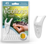 Ecofloss Mini Hammaslankain; pakkaus ecofloss mini -minttuhammaslankaimia, kuvassa kädet pitelemässä maata ja tainta; yksi valkoinen, kaareutuvapäinen hammaslankain on esillä mattapintaisen suorakulmaisen pakkauksen ulkopuolella; etiketissä selkeää groteskitypografiaa vihreällä ja mustalla; tausta valkoinen; teksti korostaa tuotteen ympäristöystävällisyyttä ja valmistusta uusiutuvasta maissista.