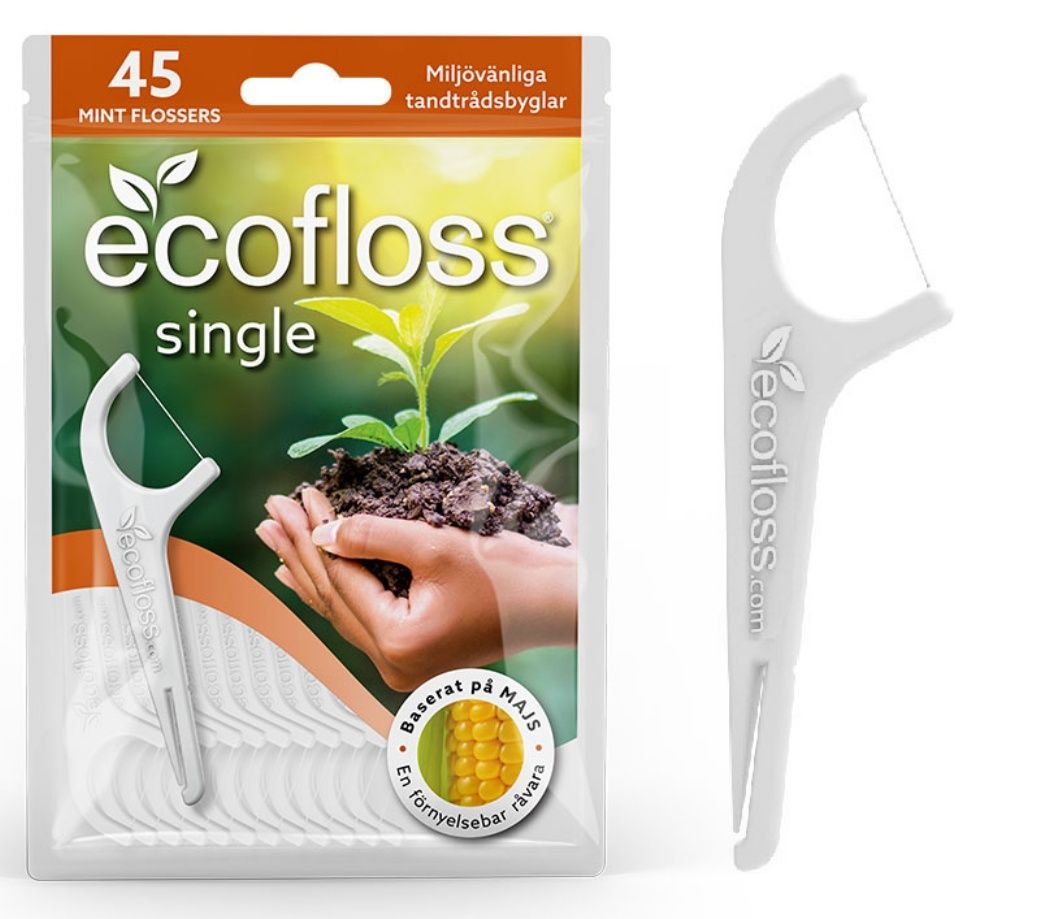 Ecofloss Single Hammaslankain; pakkaus, jossa 45 ecofloss single -minttuhammaslankainta, kuvassa kädet pitelemässä maata ja tainta, korostaa ympäristöystävällisiä, maissipohjaisia materiaaleja; pakkaus on pääosin valkoinen ja vihreä mattapinnalla, teksti selkeällä groteskifontilla; yksi biohajoava hammaslankain luonnonvalkoista muovia kaareutuvalla kahvalla ja kaksois-piikeillä on esillä erikseen oikealla yksivärista taustaa vasten.