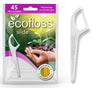 Ecofloss Slide Hammaslankain; pakkaus ecofloss slide -minttuhammaslankaimia, sisältää 45 biohajoavaa hammaslankainta, ympäristöystävällisiä väittämiä, maissikuvake ja kuva käsistä pitelemässä maata ja itävää tainta; yksi hammaslankain on esillä erikseen oikealla; pakkaus on mattapintainen vihreän ja valkoisen väreissä groteskitekstillä; erillinen hammaslankain on valkoinen kaareutuvalla kahvalla; tausta vaalea ja yksivärinen, ei ihmisiä näkyvissä.