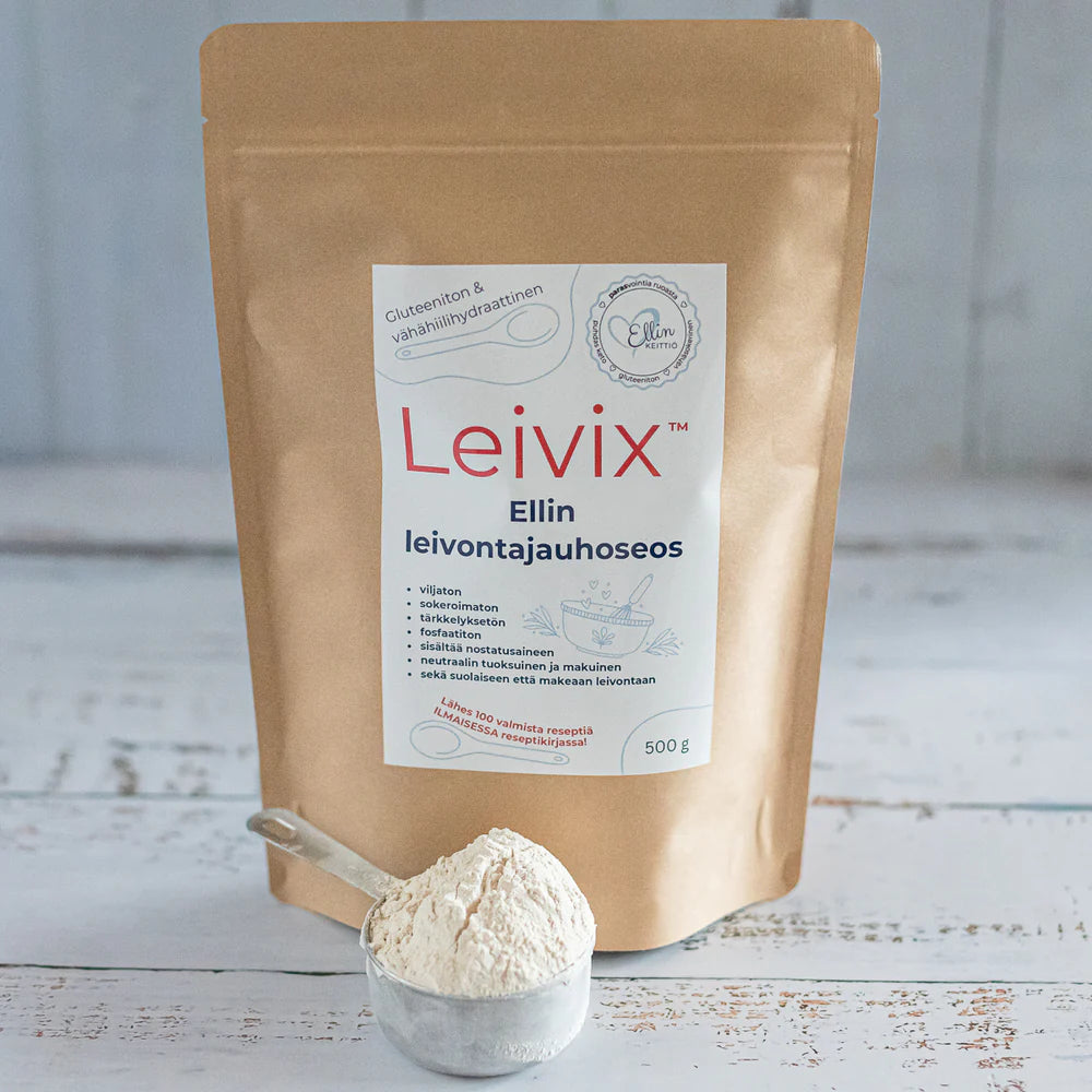 Ellin Leivontajauhoseos Leivix®; ruskea paperipussi tekstillä Leivix seisoo valkoisella pinnalla, edessä kirkas mittakuppi täynnä jauhoa; pussi suorakulmainen mattapinnalla ja uudelleensuljettavalla nauhalla, etiketin painettu teksti yksinkertainen ja lihavoitu, näyttää brändinimen ja ”500 g” suomeksi; ei ihmisiä tai käsiä, valoisa ja pelkistetty asetelma.