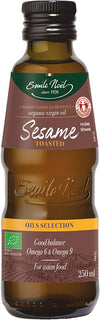 Emile Noel Luomu Paahdettu Seesamiöljy, ruskea lasipullo kiiltäväpintainen, sylinterimäinen ja kapea kaula; etiketissä vihreä-kultainen Emile Noel -brändäys, teksti "organic virgin oil", tilavuus 250 ml sekä maininta Omega 6 ja 9 rasvahapoista sekä sopivuudesta aasialaiseen ruokaan; ei ihmisiä eikä käsiä näkyvissä, tausta pelkistetty, kuva suoraan edestä silmän korkeudelta.