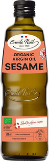 Emile Noël Luomu Seesamöljy, 500 ml pullo vihreällä korkilla, ruskea lasi ja beige-oranssi etiketti, jossa reilun kaupan ja luomusertifikaatit; pullo sylinterimäinen, korkki sileä muovia; brändinimi antiikvafontilla, muu teksti groteskifontilla; keskeiset sertifikaatit kuvakemuodossa etiketin alaosassa; tausta valkoinen, ei rekvisiittaa eikä ihmisiä, studiokuva silmän korkeudelta.