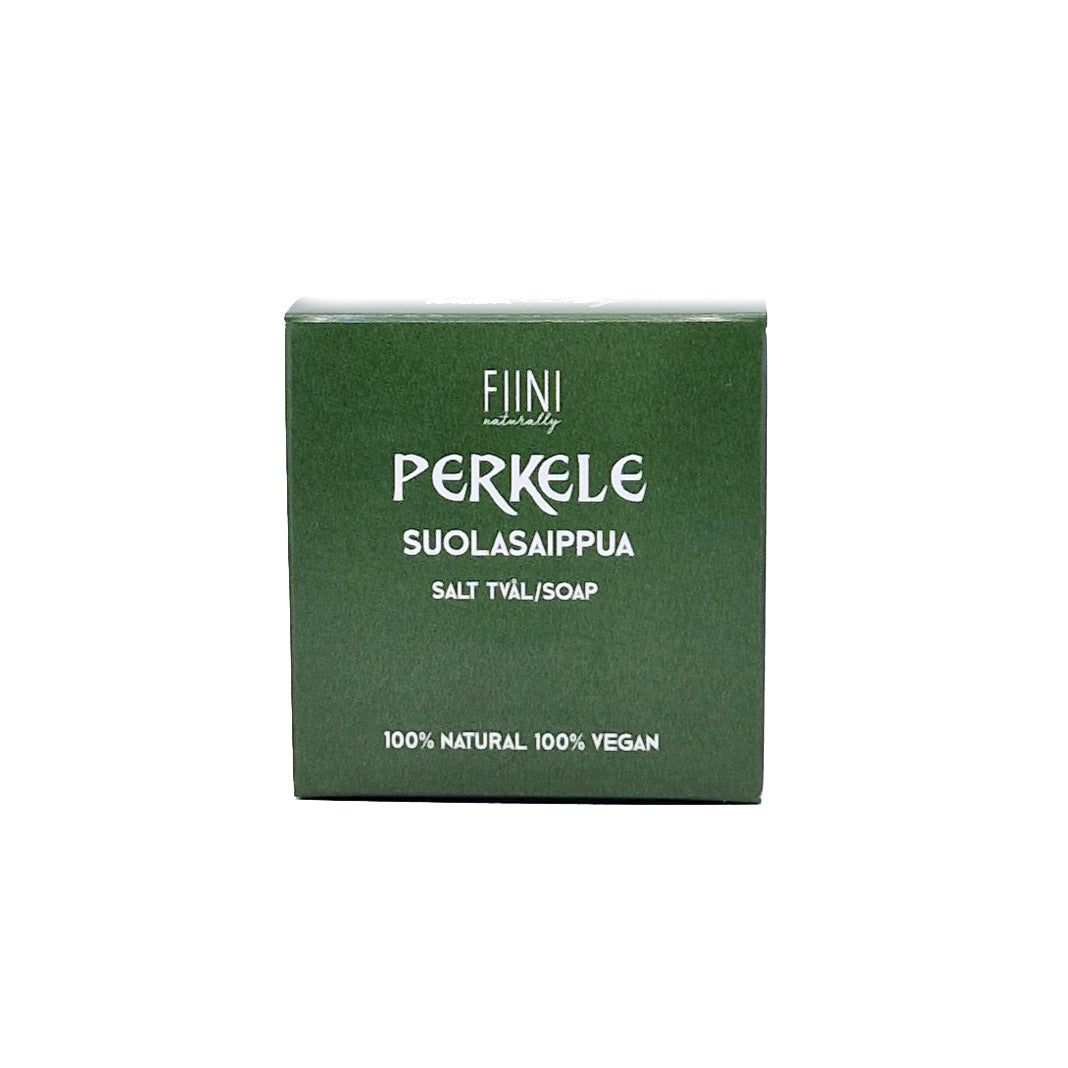 A green rectangular box of Fiini Perkele salt soap made of cardboard has a matte surface. The front displays bold, white sans-serif lettering with the words Suolasaippua, Salt Tyäl/Soap, 100% Natural, and 100% Vegan printed once. No people or hands are present. The background is plain and uncluttered. The shot is a straightforward product photo at eye level.