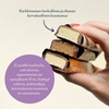 Foodin Clean & Real Protein Bar Crispy Chocolate Bliss; käsi pitelee kolmea suklaapäällystettyä jäätelöpatukkaa pinottuna yhteen; patukat soikeita kiiltäväpintaisella suklaakuorrutuksella; suomenkielinen teksti suurin selkein groteskifontein kuvaa niiden kermaista, kerroksellista rakennetta ja listaa, ettei sisällä maltitolia, sukraloosia, aspartaamia tai keinotekoisia lisäaineita; tausta yksinkertainen, kuva läheltä.