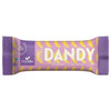 Foodin Dandy Candy Date Bar Banana Caramel; suorakulmainen, mattapintainen patukka on käärittynä violettiin ja keltaiseen pakkaukseen; kääreessä lukee lihavalla valkoisella ja keltaisella typografialla DANDY Banana Caramel, Candy Date Bar sekä No added sugar; 35 gramman patukan valmistaja on FOODIN; kuvassa ei näy ihmisiä tai käsiä, tausta on yksivärinen.
