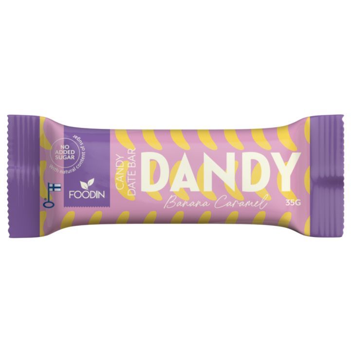 Foodin Dandy Candy Date Bar Banana Caramel; suorakulmainen, mattapintainen patukka on käärittynä violettiin ja keltaiseen pakkaukseen; kääreessä lukee lihavalla valkoisella ja keltaisella typografialla DANDY Banana Caramel, Candy Date Bar sekä No added sugar; 35 gramman patukan valmistaja on FOODIN; kuvassa ei näy ihmisiä tai käsiä, tausta on yksivärinen.