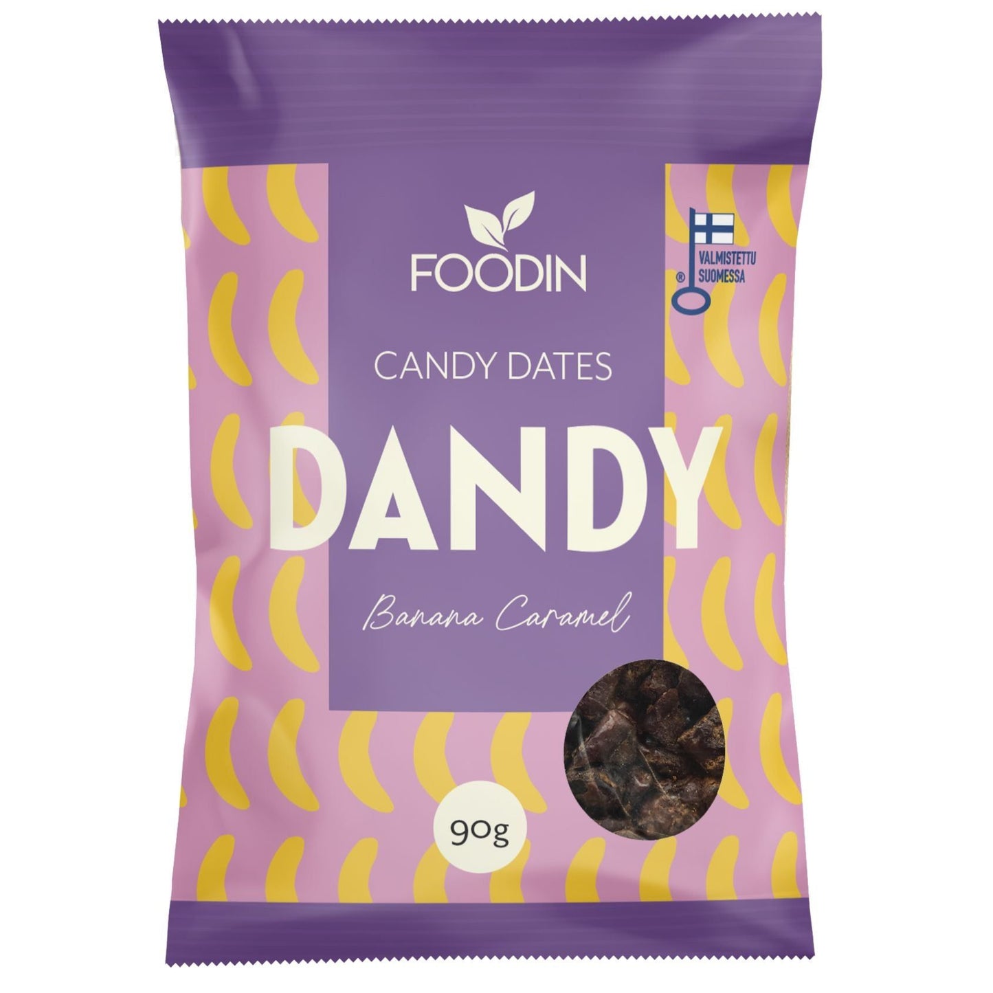 Foodin Dandy Candy Dates Banana Caramel; violetti mattapintainen pussi Foodin Dandy Candy -taateleita, Banana Caramel -maku, 90 g; etusivulla tyyliteltyjä keltaisia banaanikuvia ja kirkas ikkuna, josta osa sisällöstä näkyy; oikeassa yläkulmassa Suomen lipun kuvake ja teksti ”valmistettu Suomessa”; tausta tasainen ja neutraali; suora tuotekuva ilman ihmisiä tai käsiä.