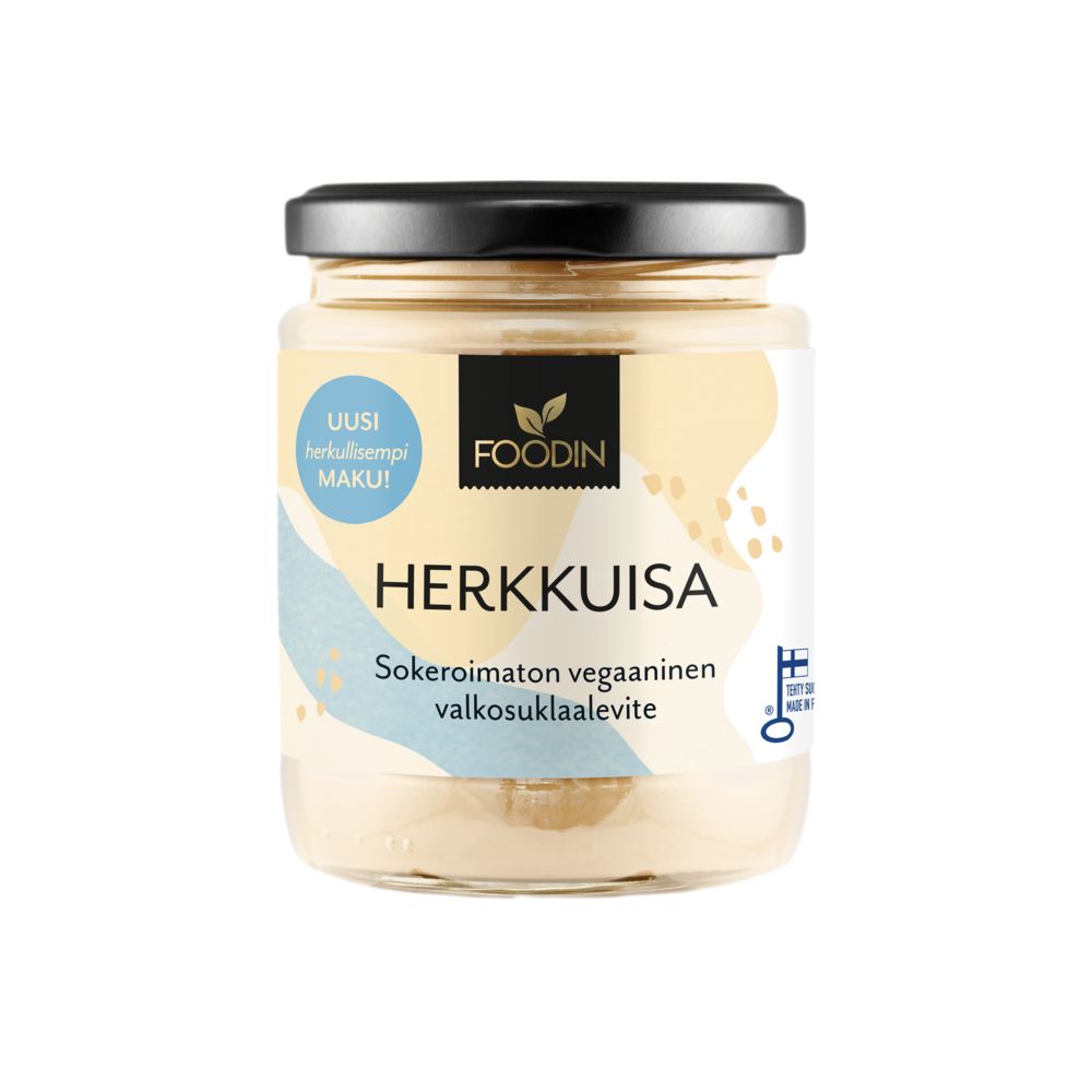Foodin Herkkuisa Valkosuklaalevite Sokeroimaton; purkki mustalla kannella ja pastellisävyisellä etiketillä suomenkielisin tekstein, oikeassa reunassa pieni sininen pyöreä vegaanimerkki; purkki sylinterinmuotoinen kirkasta lasia, näkyvissä luonnonvalkoinen levite; etiketin teksti groteskikirjasimella; valkoinen tausta ilman muita esineitä tai ihmisiä.