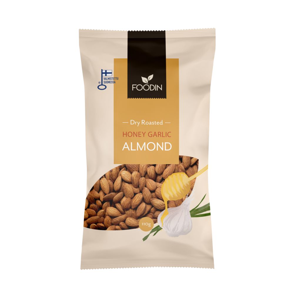 Foodin Honey Garlic Almonds; pussi Foodin Dry Roasted Honey Garlic Almonds -manteleita, pakkauksessa kuvia manteleista, valkosipulinkynnestä, vihreistä yrteistä ja hunajakauhasta; mattapintainen seisova pussi pääosin ruskea valkoisin tekstein modernilla groteskifontilla; etusivulla merkintä ”110 g”, suomalainen laatumerkki ja mainintoja hunajan ja valkosipulin mauista; tasainen studiotausta, ei ihmisiä tai toimintaa näkyvissä.