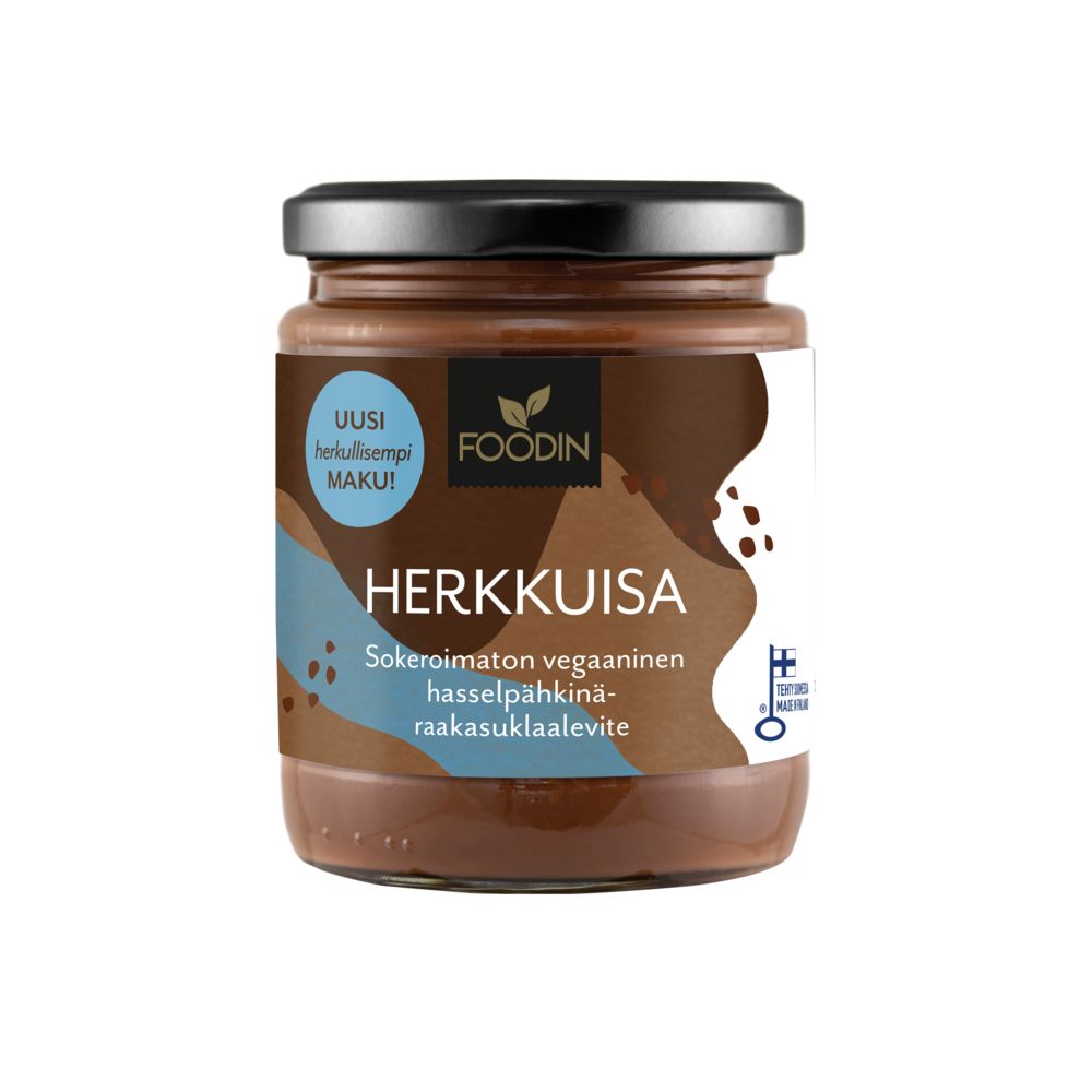 A jar of Foodin Herkkuisa, a delicious sugar-free vegan hazelnut chocolate spread featuring Finnish text and a black lid, is pictured against a white background. The cylindrical jar is clear glass or plastic with a matte paper label, displaying simple sans-serif and handwritten-style fonts. Label includes “HERKKUISA” in bold uppercase. The product sits upright on an even surface; no people or props are visible.