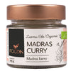 A glass jar with a capacity label of 25g contains Foodin Madras Curry powder and has a copper-colored metal lid. The label features a detailed botanical illustration, the Foodin logo, and product name in clean, modern typography; “organic” is also legible. The surface of the jar is smooth and glossy. No hands or people are present. The background is neutral and uncluttered.