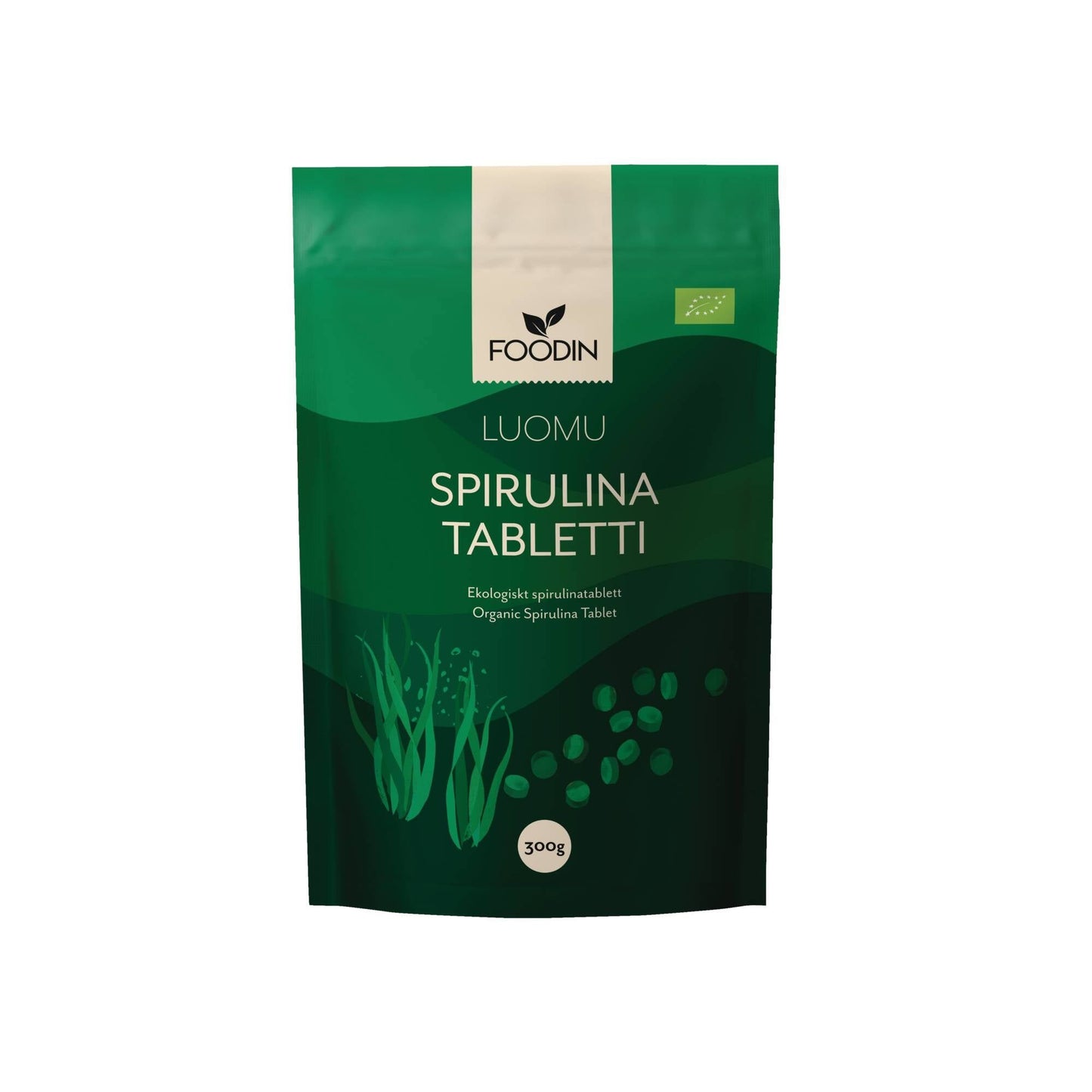 Foodin Luomu Spirulina Tabletti, 300 g; vihreä, suorakulmainen, mattapintainen pakkaus, jossa tyyliteltyjä merileväkuvituksia ja kirkkaanvihreitä korostuksia; pyöreä etiketti alaosassa; groteskityyppiä; tuote kuvattu neutraalilla taustalla studiokuvassa.