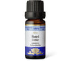 A brown glass bottle labeled Aito Setri Cedar essential oil with a black cap. The bottle is cylindrical with a smooth, glossy surface. The label has blue accents, a floral graphic, and simple sans-serif typography. “Cedrus atlantica” is listed as the ingredient. Product appears against a plain background in a centered product shot.