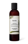 A bottle of Frantsila Herb Farm Nettle Conditioner with a dark cap and label featuring plant illustrations and bilingual text highlighting the nourishing benefits of nettle. The bottle is cylindrical, opaque white or light-colored plastic with a matte finish. The label is primarily green-toned, decorated with botanical drawings. Text is printed in both Finnish and English, using clean sans-serif fonts. The product stands upright on a plain white background in a well-lit studio shot. No people or hands are
