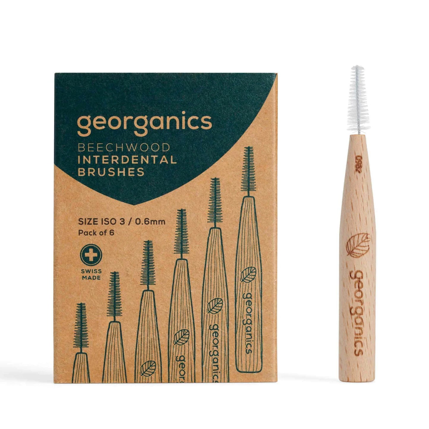 Georganics Hammasväliharja 0.6 mm: ruskea mattapintainen kartonkirasia, jossa kuvitettuna kuusi hammasväliharjaa ja teksti "SIZE ISO 3 / 0.6mm Pack of 6"; rasian vieressä yksi harja, jonka varsi on vaaleaa puuta ja siinä on georganics-logo; pakkaus on suorakulmainen, groteskikirjasin on yksinkertainen; kuva otettu ylhäältä, ei ihmisiä tai käsiä näkyvissä.